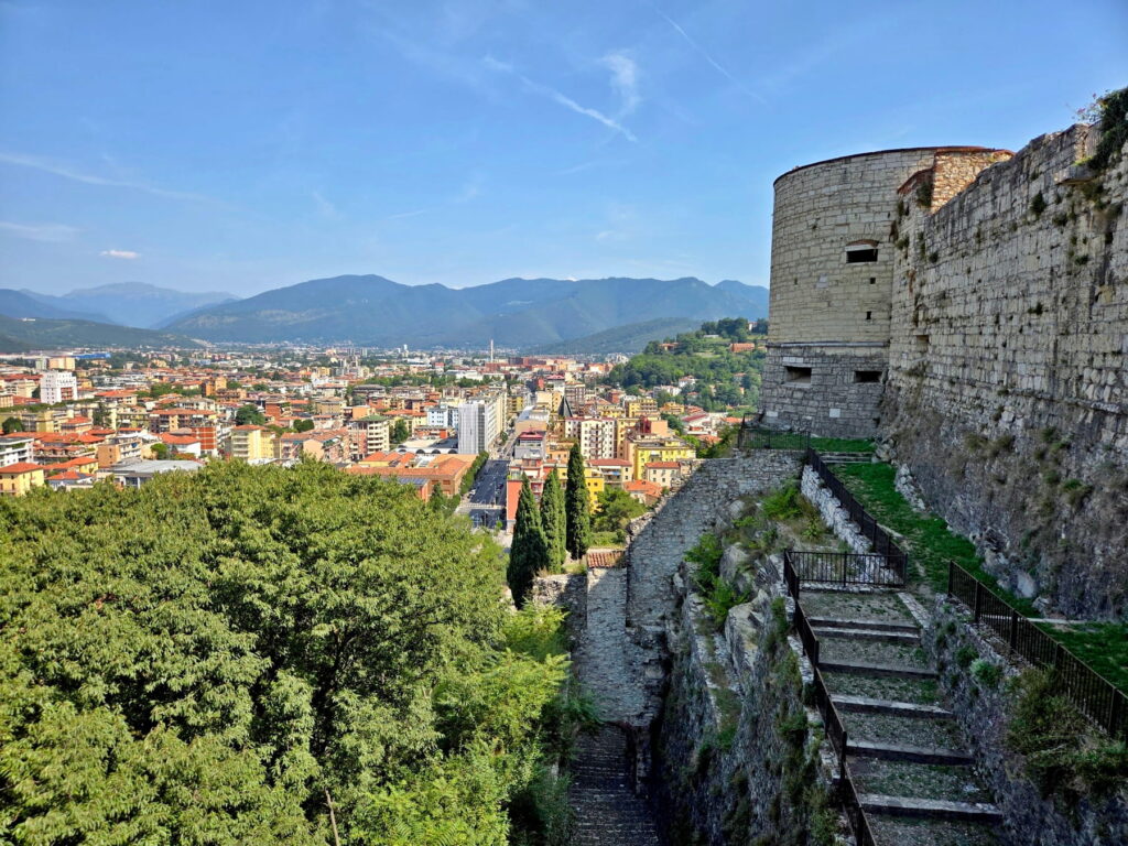 View of Brescia city and distant mountains from the stone bastions of Brescia Castle.