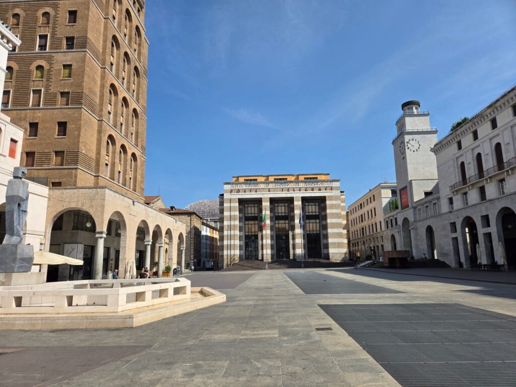 Piazza della Vittoria square in Brescia, Italy, with Torre della Rivoluzione and arcaded buildings