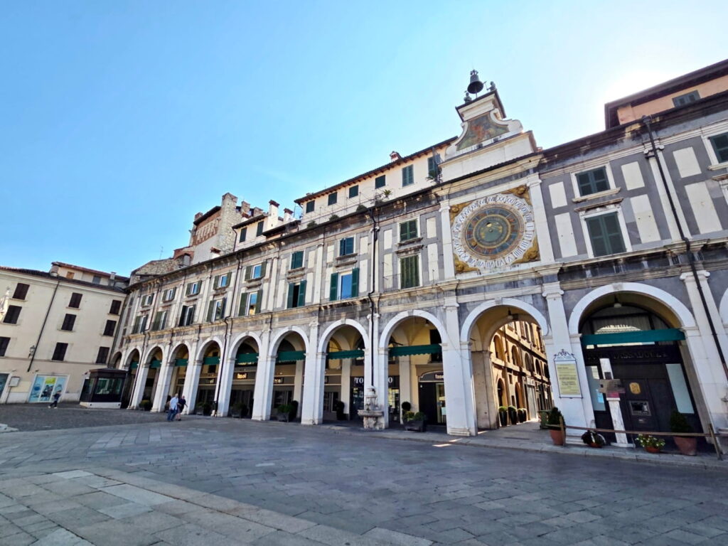 Astronomical clock on Piazza della Loggia in Brescia, Italy, with arcaded Renaissance building facade