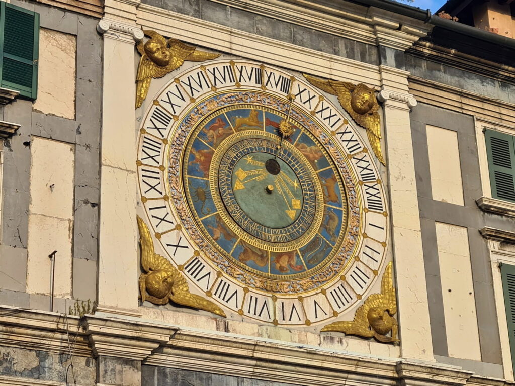 Astronomical clock detail in Brescia, Italy, with zodiac symbols and golden angels on Piazza della Loggia