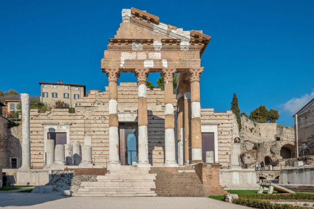The reconstructed front facade of the Capitolium temple featuring marble columns and original Roman inscriptions.