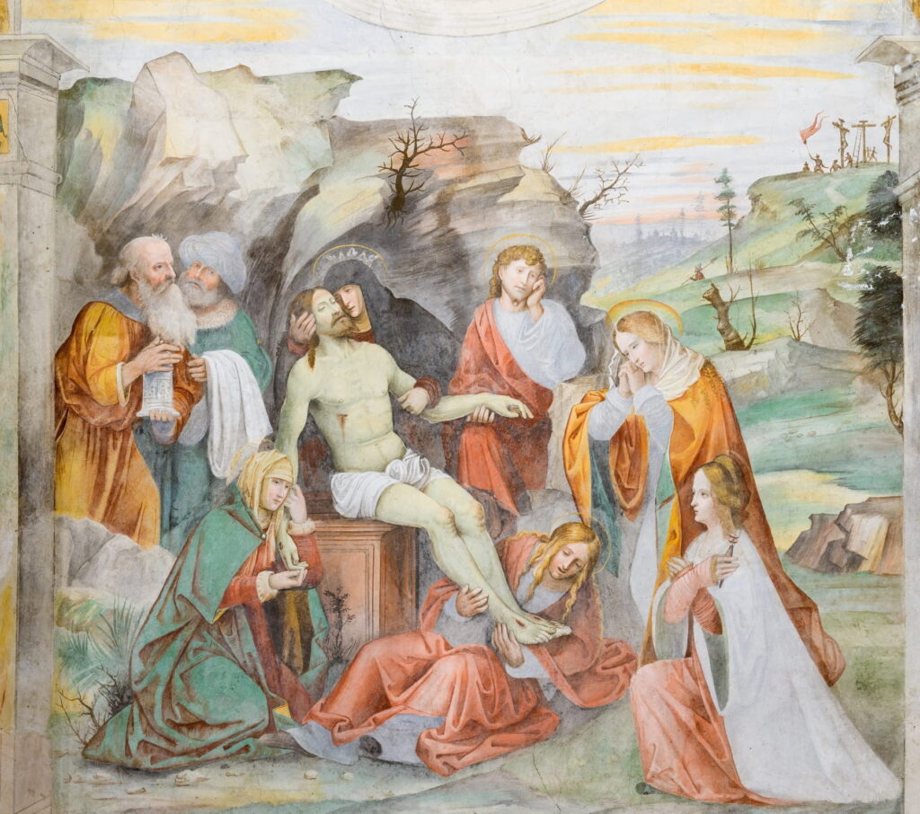A detailed religious fresco showing a biblical scene with figures in colorful robes on a plaster wall.